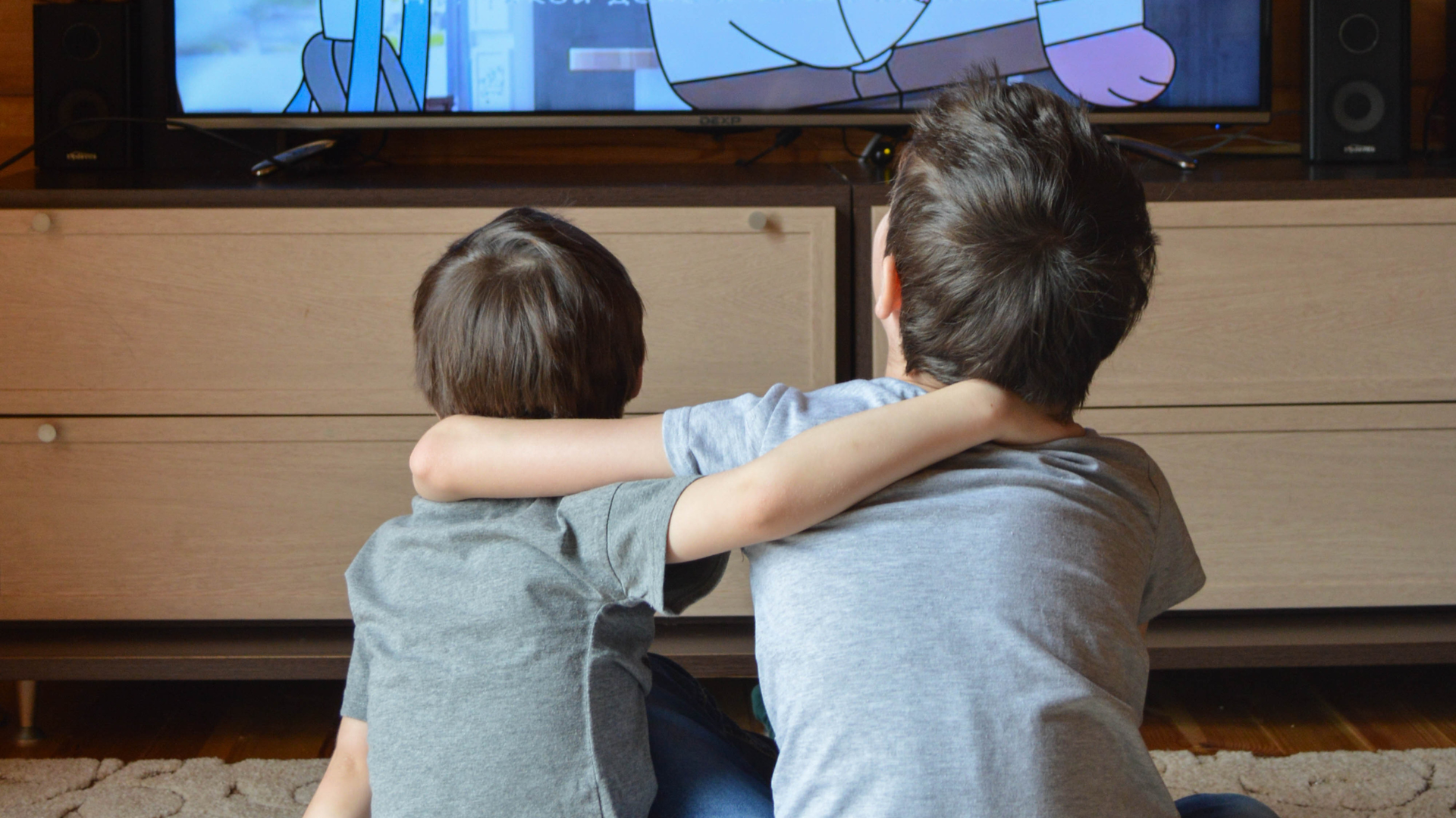 Two children watching an animated series on TV together