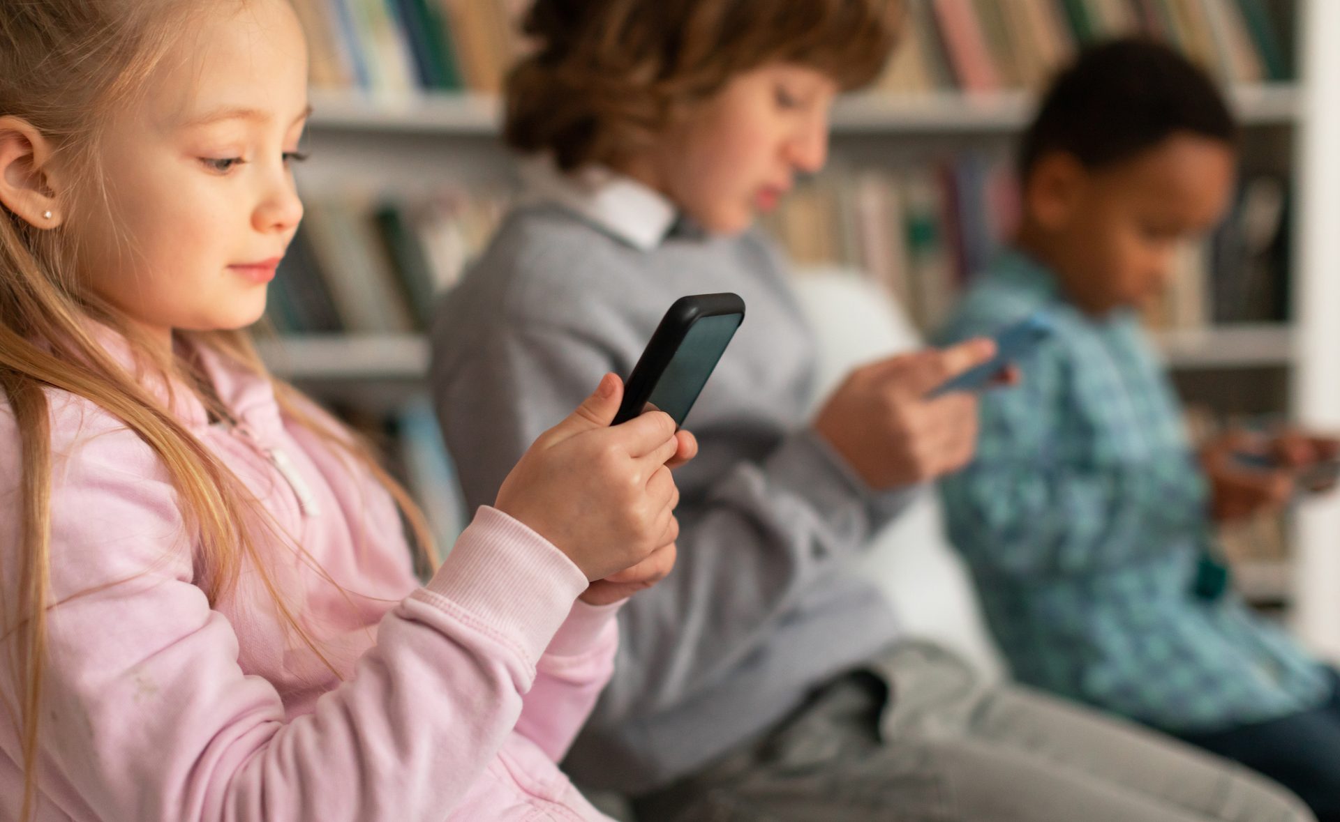 Chicos usando celulares en un aula, contexto de audiencias U18 alcanzadas por el ECA Digital en Brasil