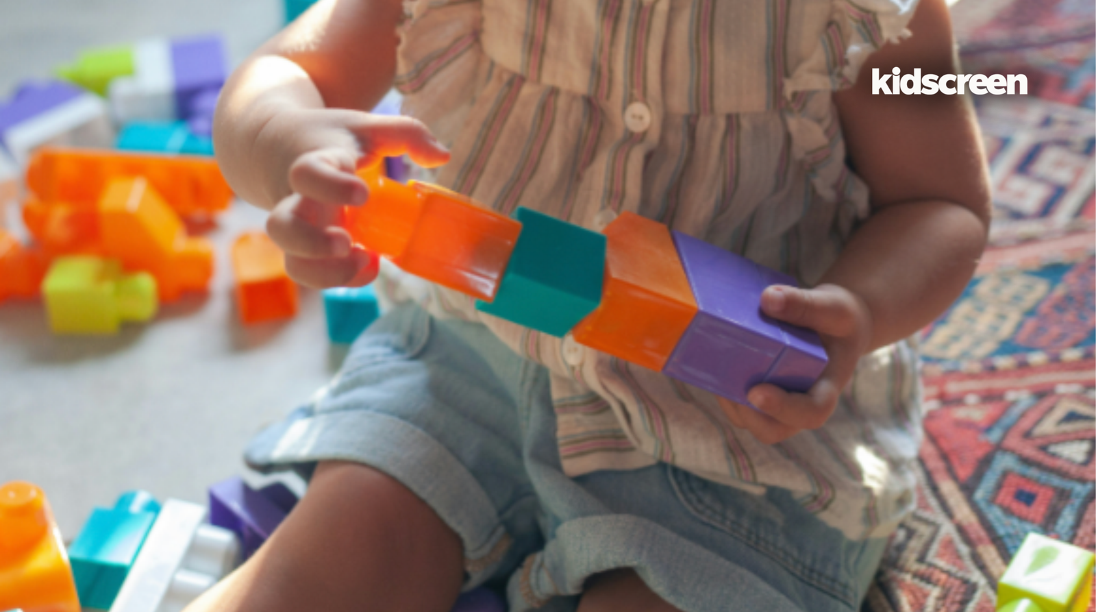 Criança brincando com blocos de montar coloridos, imagem que ilustra a queda da brincadeira com brinquedos entre as crianças nos EUA
